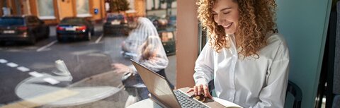 Frau im Café am Laptop
