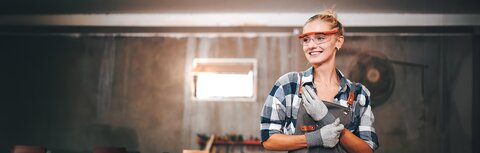 Freundliche Handwerkerin in Werkstatt