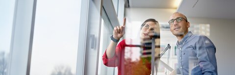 Mann und Frau betrachten etwas im Büro