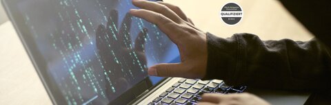 Hand eines stilisierten Hackers auf Laptop-Bildschirm
