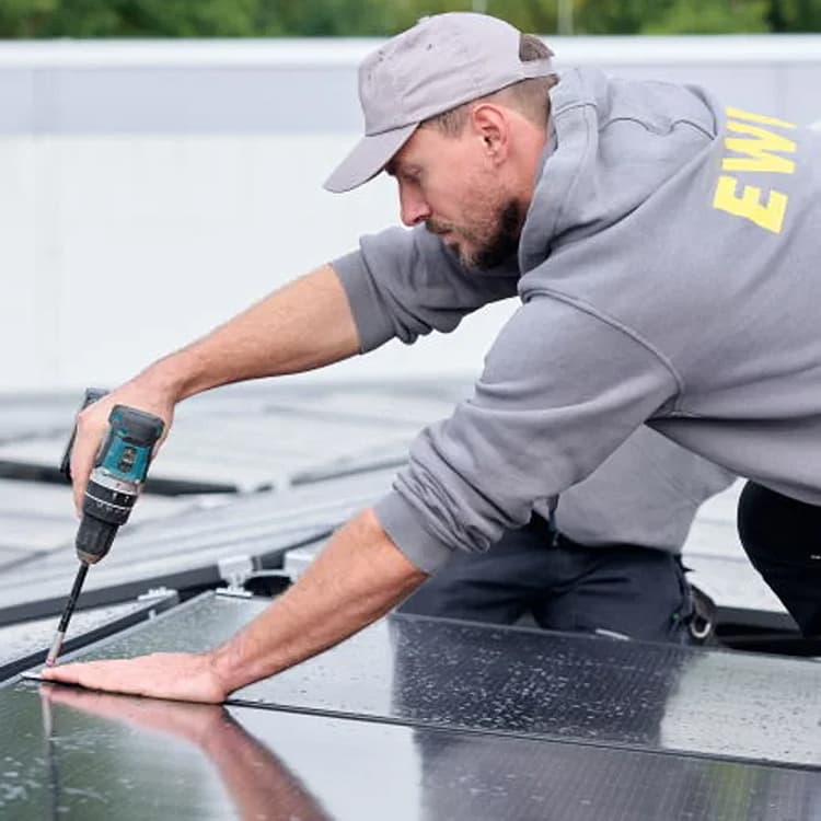 Mitarbeiter von EWE installiert Solarmodul