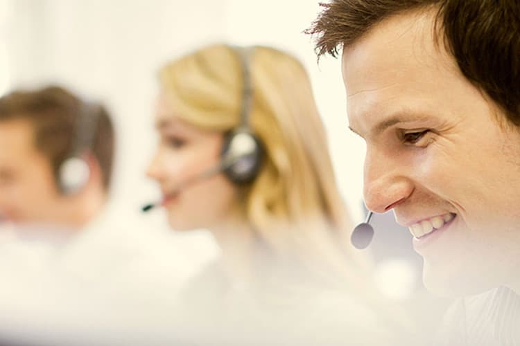 Drei freundliche Personen mit Headsets