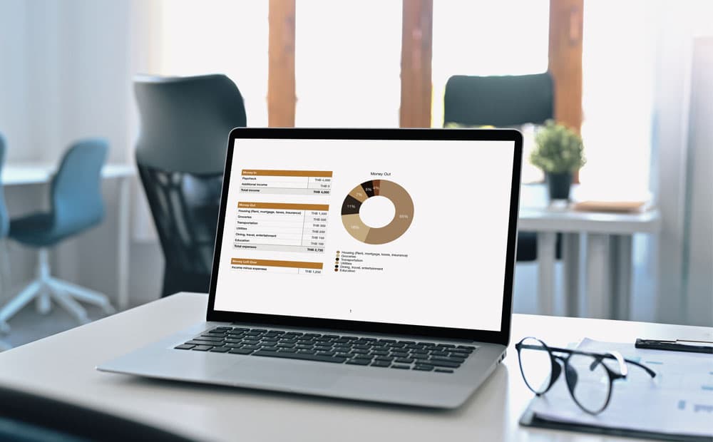 Ein Laptop mit Grafik, daneben eine Brille auf einem Schreibtisch