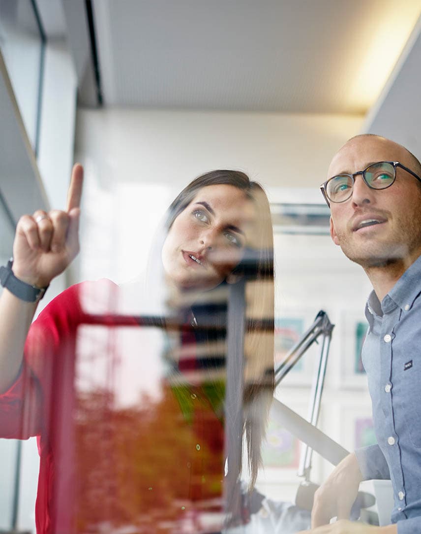 Eine Frau und ein Mann betrachten etwas im Büro.