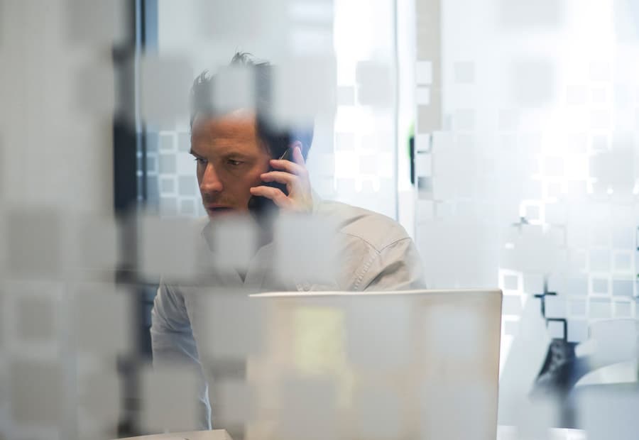 Ein Mann in einem Büro, der telefoniert und einen ernsten Gesichtsausdruck hat