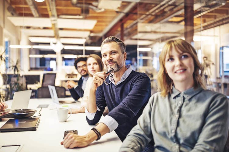 Eine Frau und ein Mann an einem Bürotisch, die auf etwas schauen