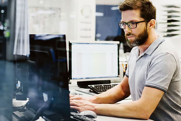 Mann mit Brille am Dektop-PC