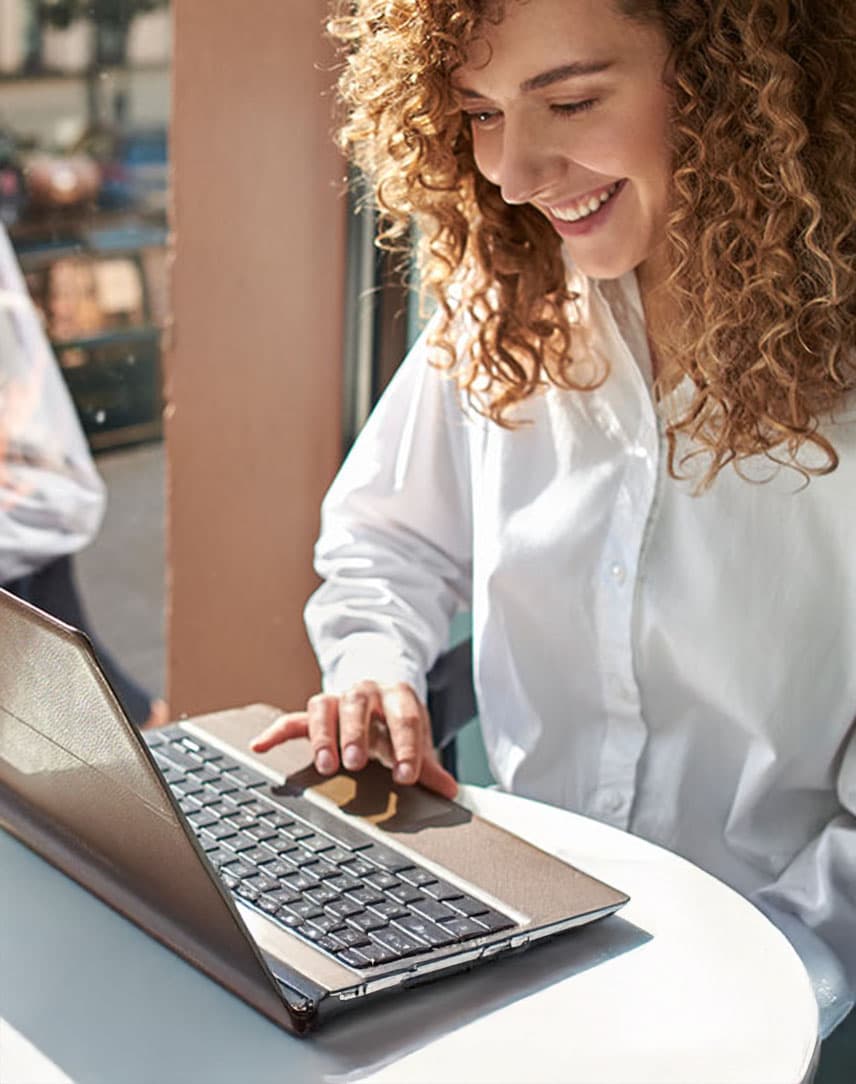Frau sitzt im Café am Laptop