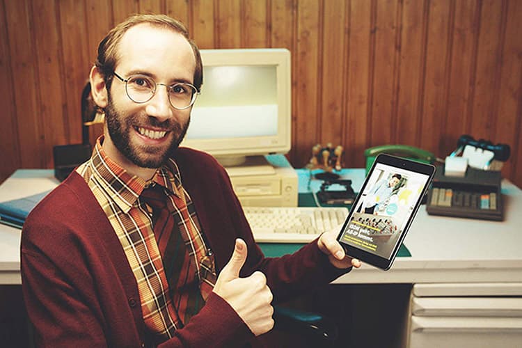 Mann am Schreibtisch mit Tablet in der Hand