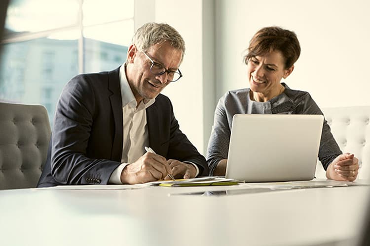 Zwei Business Kolleg:innen am Laptop