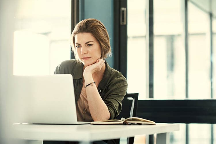 Frau betrachtet interessiert Laptop-Bildschirm
