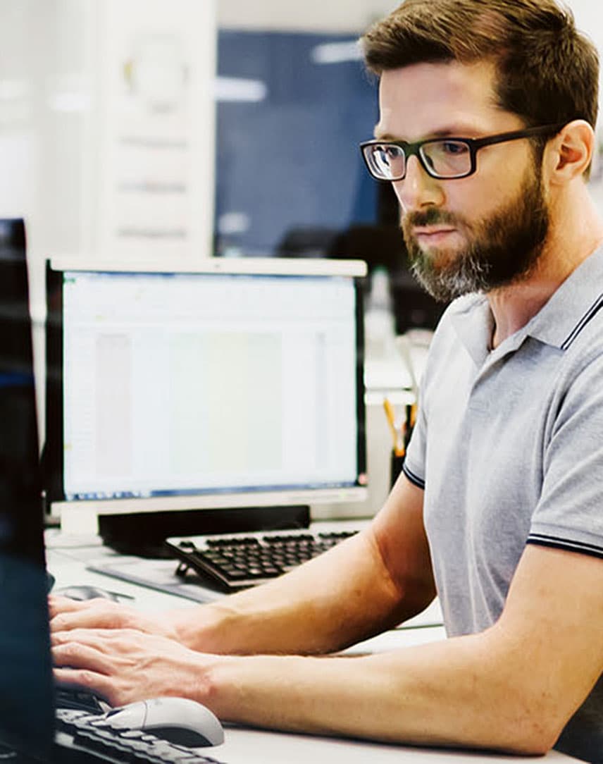 Mann mit Brille am Dektop-PC