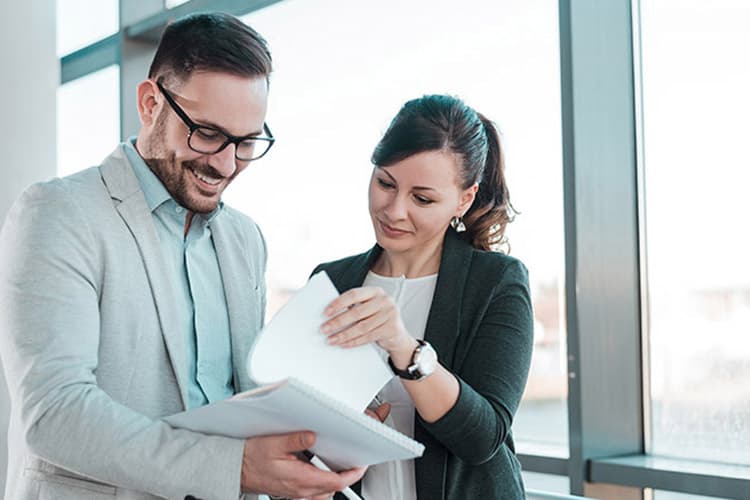 Ein Mann und eine Frau blättern durch Dokumente