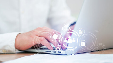 Bildkomposition: Hand am Laptop und verschiedene Icons zu IT-Security