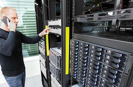 Mann telefonierend am Handy im Serverraum