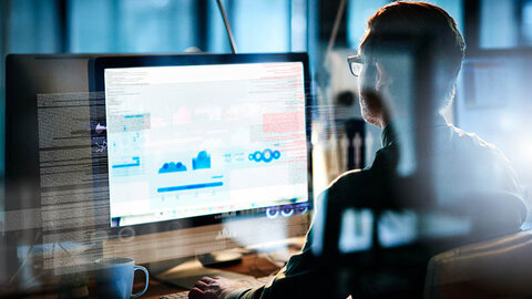 Mann schaut auf Computerbildschirm mit Daten