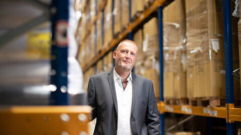 Mann im Anzug in Lagerhalle