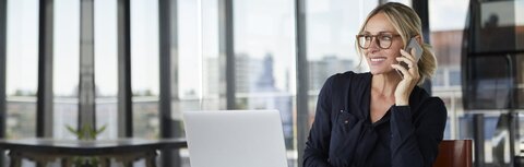 EWE Beraterfinder für Geschäftskunden Geschäftsfrau im Gespräch mit einem Smartphone in der Hand