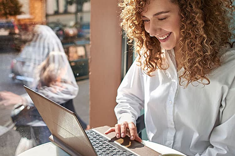 Frau sitzt im Café am Laptop