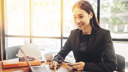 Abrechnung Frau mit Tablet am Notebook