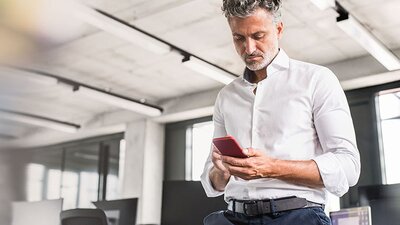 EWE Mailscan+ Mann im weißen Hemd am Handy