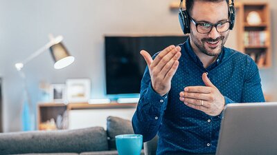 EWE Security Awareness Mann mit Headset erklärt etwas vor dem Laptop