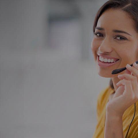Termin vereinbaren Eine Frau mit Headset, die lächelt